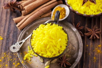 bright-yellow-boiled-rice-with-turmeric-and-aromatic-spices-on-a-dark-wooden-background-in-old-vintage-metal-bowl-2