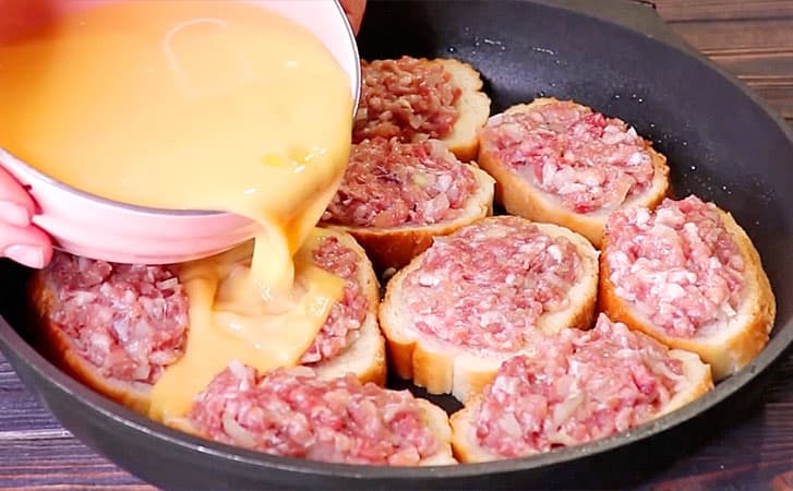 Нарезаем батон и распределяем сверху фарш для сочного, вкусного мясного пирога без хлопот с тестом
